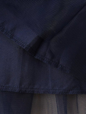 Navy tulle baby dress detail showing layered fabric and stitching.