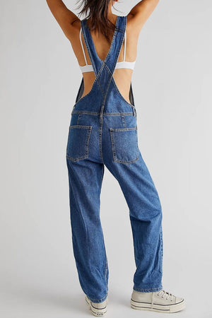 Relaxed fit denim overalls in medium wash with crisscross straps and back pockets.