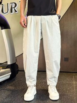 Light gray cargo pants with adjustable cuffs and pockets, worn by a person.