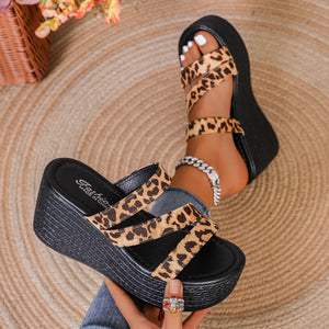 Leopard print platform wedge sandals with crisscross straps and a black sole.