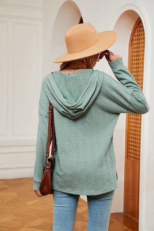Green textured henley hoodie with drop shoulder and cable knit pattern.