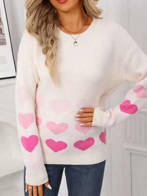 Cream crew neck sweater with allover pink heart print and ribbed cuffs.