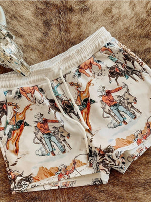 White drawstring shorts with a vintage rodeo print and elastic waistband.