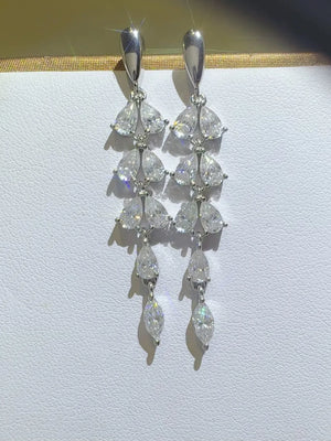 Silver cascading moissanite pear drop earrings with multiple tiers of marquise and pear-shaped stones.
