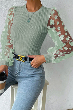 Sage knit blouse with sheer floral appliqué sleeves and crew neck.