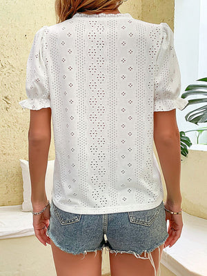 White eyelet embroidered puff sleeve blouse with ruffled cuffs.