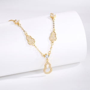 Gold Y-lariat necklace with zircon adorned gourd charms and a central teardrop pendant.