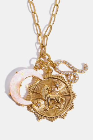 Gold pendant necklace with Leo zodiac, moon, and S-shaped charm.