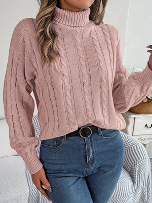 Dusty pink cable knit turtleneck sweater with voluminous sleeves and textured stitch details.