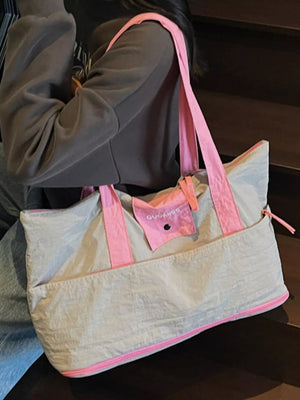 Premium two-tone nylon travel bag in grey with pink trim and straps.