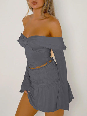 Dark gray ruched bodice off-shoulder top with long bell sleeves and lettuce trim.