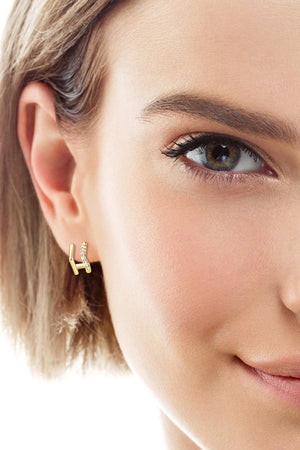 Gold geometric pavé ear jackets with cubic zirconia accents.