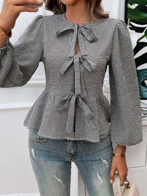 Black gingham peplum blouse with puff sleeves and three bow details.