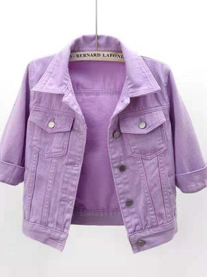 Lavender denim trucker jacket with cropped sleeves and button pockets.