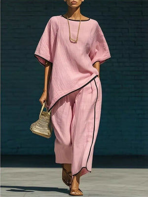Pink two-piece set with contrast trim, featuring a cropped pants and loose top.