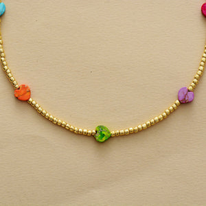 Gold beaded necklace with multicolor heart charms