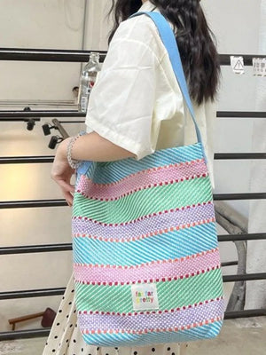 Vibrant striped woven shoulder bag with blue strap and colorful wavy stripes.