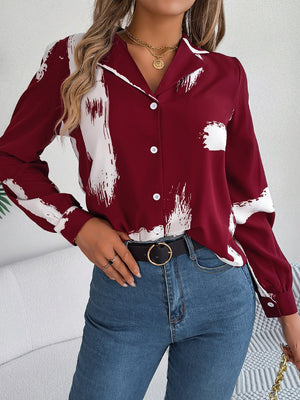 Burgundy collared blouse with white brushstroke print, button front, and long sleeves.