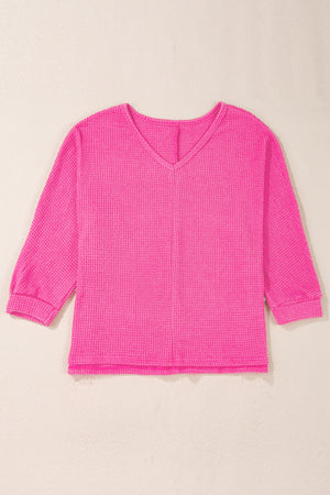 Hot Pink waffle knit v-neck top with 3/4 sleeves and a slit hem.