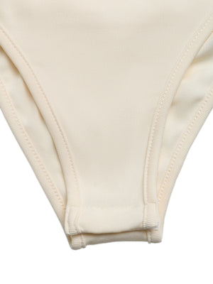 Cream sleeveless bodysuit with snap closure and ribbed trim.