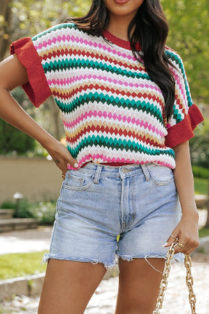Textured knit sweater with colorful stripes and contrast red trim on sleeves and neckline.