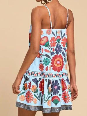 Light blue mini dress with vibrant floral print, spaghetti straps, and tiered hem.