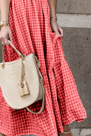 Red gingham smocked maxi dress with flutter sleeves and tiered skirt detail.