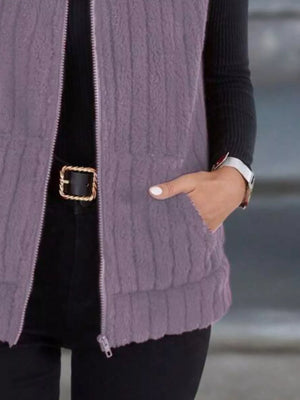 Purple fleece zip-up vest with textured stripes and pockets, worn over black clothing.