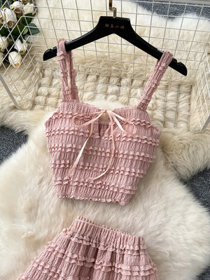 Pink ruched crop top and maxi skirt set with ribbon tie and frill details.