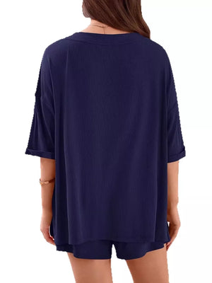 Navy V-neck two-piece loungewear set with ribbed texture and cuffed sleeves.