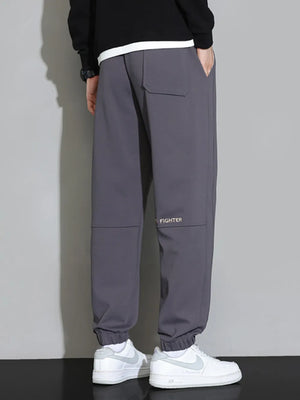 Men's grey cuffed jogger pants with a back pocket and subtle logo detail.