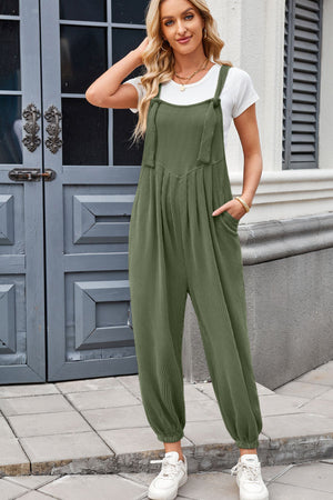 Olive corduroy overalls with barrel leg and pleated detail, worn with a white t-shirt.