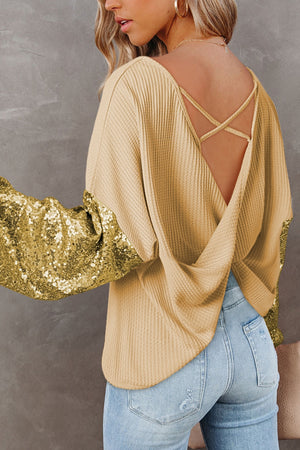 Light yellow waffle knit top with sequin sleeves and crisscross back detail.