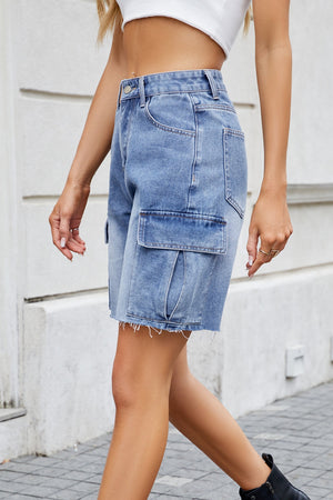 Medium wash denim bermuda shorts with raw hem and cargo pockets.