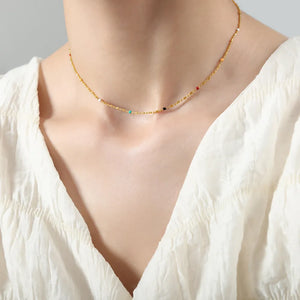 Gold beaded necklace with colorful accent beads, a delicate and artistic boho style.