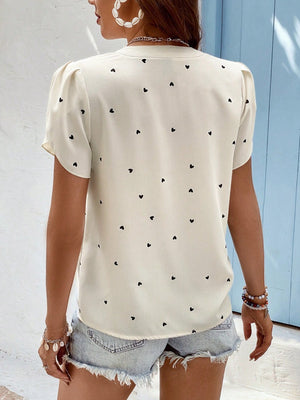 Cream heart print puff sleeve blouse with a v-neckline.