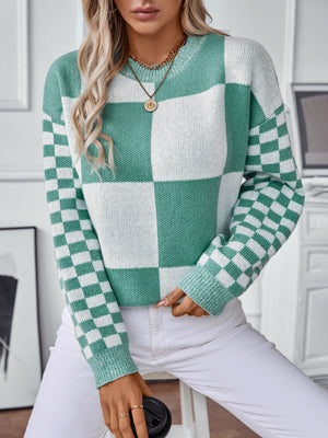 Checkerboard knit sweater in turquoise and white with a crew neck and long sleeves.