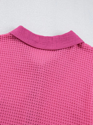 Waffle-knit button-down shirt in cerise pink with a collared neckline.