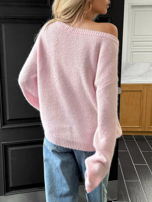 Blush pink ribbed knit one-shoulder sweater with long sleeves.