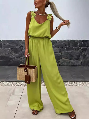 Yellow green wide-leg jumpsuit with floral applique straps and blouson waist.