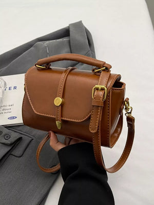 Brown pu leather mini crossbody bag with clasp and adjustable strap.