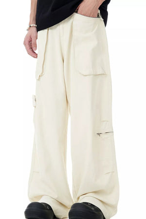 Relaxed cream cargo pants with multiple pockets and zipper details.