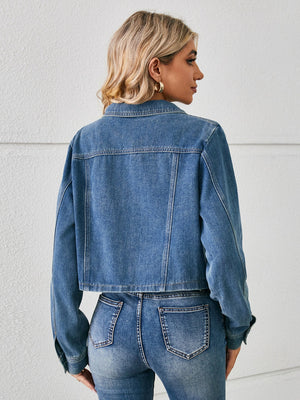 Cropped denim trucker jacket in dusty blue with buttoned front and collar.