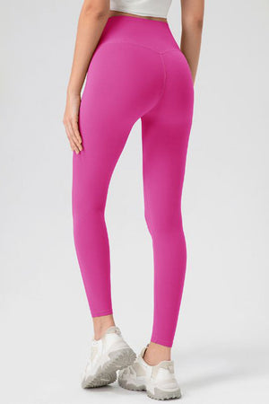 Pink high-waist performance leggings with sculpting seam detail and full length.