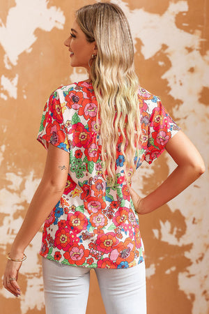 Retro floral v-neck cap sleeve blouse in multicolor with a white base and vibrant red, pink, and blue flowers.