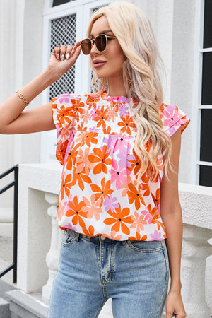 Multicolor floral smocked bodice flutter sleeve blouse with a high neckline.