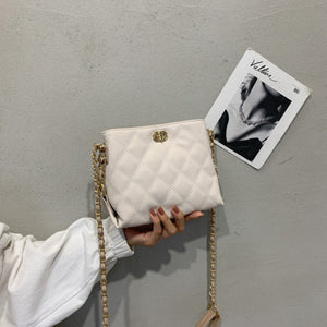 White quilted crossbody bag with diamond pattern and gold chain strap
