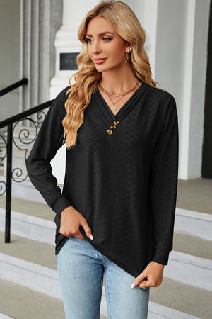 Black textured henley v-neck top with button detail and long sleeves.