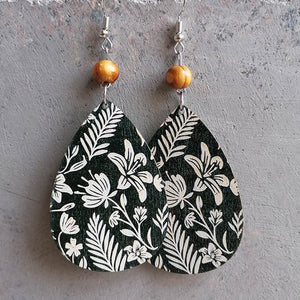 Botanical drop earrings with wood bead, white floral pattern on dark green.