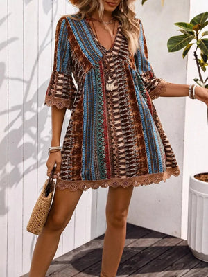 Bohemian printed v-neck dress with bell sleeves and lace trim, featuring a colorful pattern.